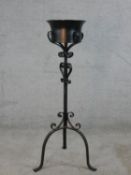 A 20th century painted iron jardinière in a painted scrollwork stand raised on splayed supports