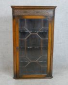 A George III mahogany hanging corner cupboard with single astragal glass door opening to revel three