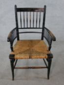 A 19th/early 20th century ebonised spindle back chair with straw seats raised on turned supports and