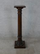 An early 20th century carved mahogany jardinière stand with fluted central column, raised on