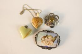 A white metal framed brooch with hand painted porcelain plaque of two angles along with a silver and