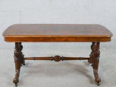 A 19th century walnut veneered centre table raised on two turned columns raised on outswept supports