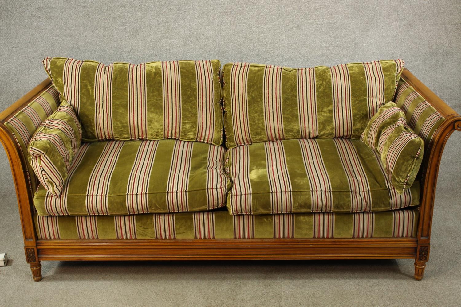 An early 20th century bergère and beech scroll arm two seater settee raised on fluted tapering