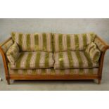 An early 20th century bergère and beech scroll arm two seater settee raised on fluted tapering