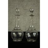 A pair of early 20th century glass decanters and stoppers each etched with grape and vine