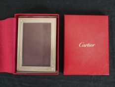 A mid 20th century boxed Cartier white metal photograph frame. H.3 W.16 D.21cm