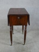 A 19th century mahogany drop leaf sewing table, with twin drawers to one end, raised on turned