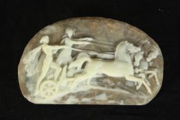 A cameo design moulded resin statement belt buckle depicting a horse pulled chariot and riders. H.