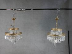 A pair of 20th century gilt metal and glass two tier hanging electroliers. H.62 W.38 D.38cm