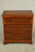 A contemporary Yew wood bachelors style chest of four graduating drawers with rotating foldover