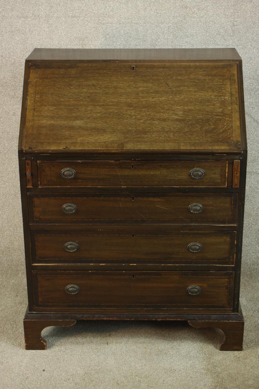 An early 20th century stained mahogany bureau, the fall front opening to reveal fitted interior,