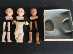 Three painted 20th century porcelain dolls and limbs. H.22 W.25 D.6cm