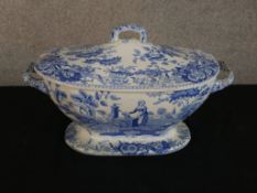 A 19th century blue and white Spode twin handled lidded tureen, decorated with figures in a garden