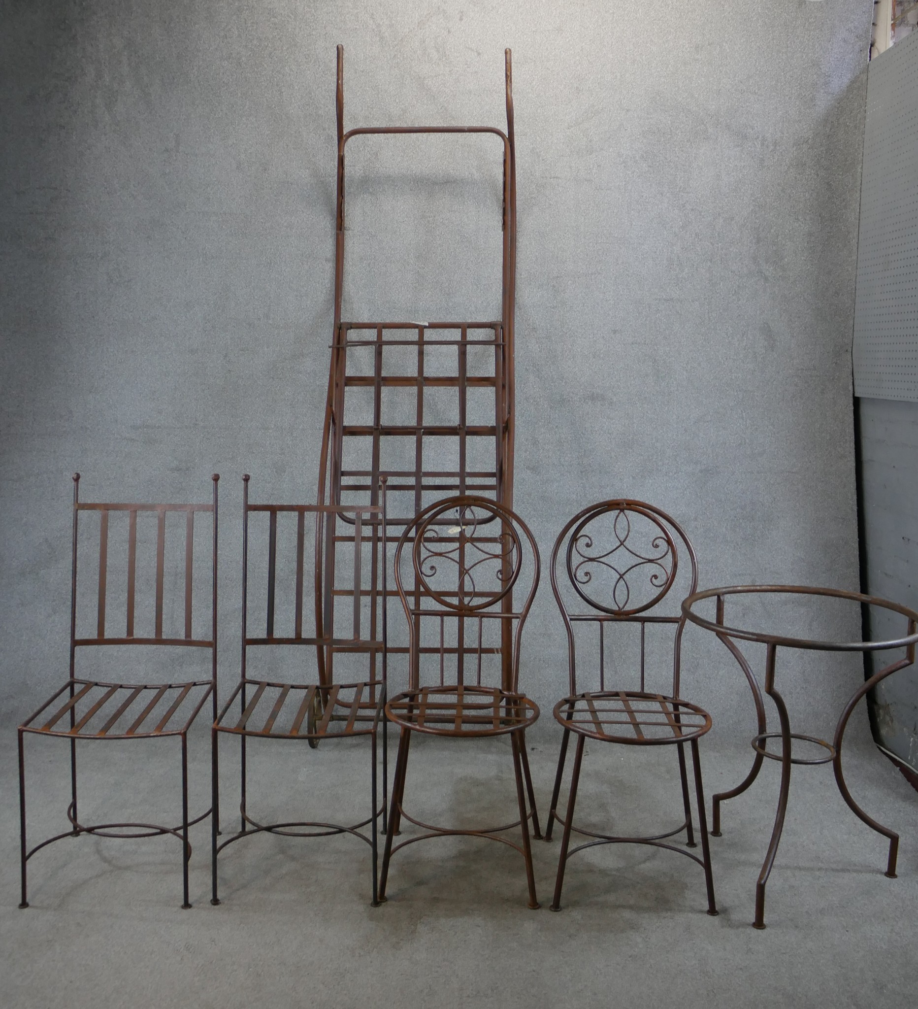 Two pairs of wrought iron garden chairs, together with a wrought iron garden table and a wrought