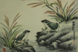 A 20th century, Japanese school, frogs on a rock, with calligraphy and seal marks, framed. H.43 W.