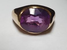 A 14 carat yellow gold and amethyst dress ring, set to centre with a mixed cut cushion shaped