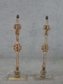A pair of painted wrought iron Gothic style table lamps mounted to wooden supports raised on stepped