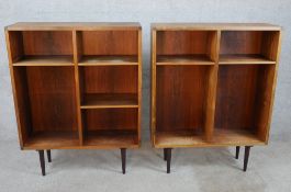 A pair of mid 20th century Danish rosewood open display shelves each raised on tapering supports.