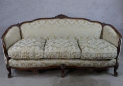 A late 19th/early 20th century carved French stained beech framed three seater settee, upholstered