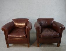 A pair of contemporary brown leather club style armchairs, raised on shaped mahogany supports.