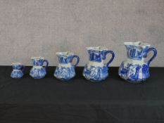 A contemporary graduating set of five blue and white pottery jugs. H.24 W.24 D.21cm Largest