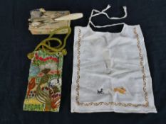 A 19th/ early 20th century sewing kit, together with an embroidered bag and a child's bib. H.27 W.