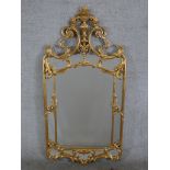 A 20th century Italian gilt framed framed wall hanging sectional mirror, mounted with urn and scroll