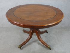 A 19th/early 20th century inlaid mahogany circular tilt topped table, raised on four splayed