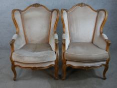 A pair of early 20th century French carved stained beech armchairs raised on carved cabriole