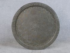 A 20th century engraved, possibly Moroccan circular brass charger with all over engraved decoration.