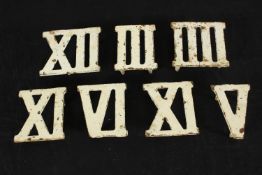 Seven painted cast iron Roman numerals. H.3.5 W.9 D.8.5cm. (largest)