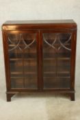 An early 20th century mahogany two door door display cabinet raised on shaped bracket feet. H.84 W.