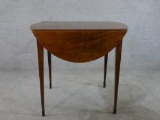 A George III mahogany Pembroke table raised on square tapering supports terminating in spade feet.
