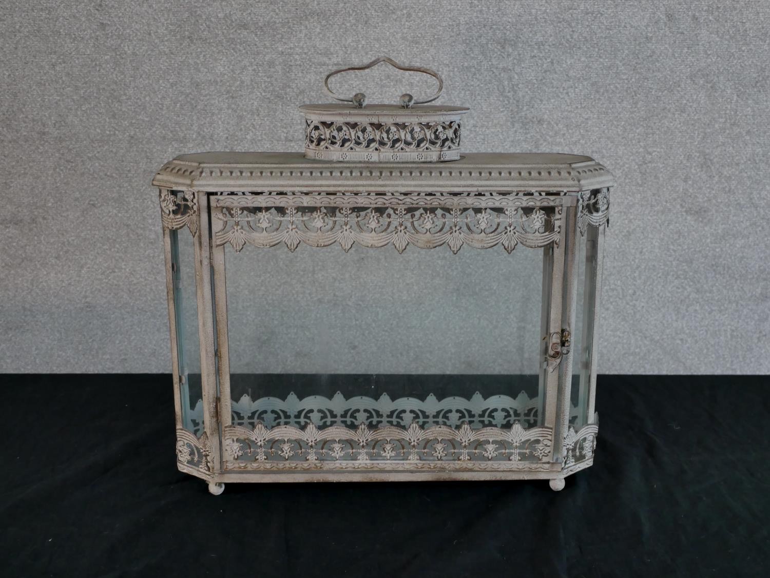 A contemporary painted metal and glass storm lantern, with carrying handle. H.51 W.48 D.13cm