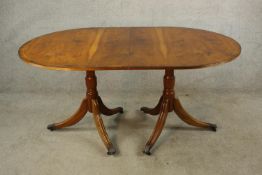 A contemporary Yew wood Regency style twin pillar dining table each pillar raised on turned