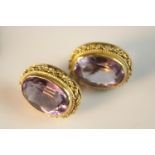 A pair of 18ct amethyst earrings. Each set with an oval mixed cut amethyst in a filigree rope