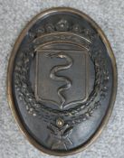 A 19th century cast bronze oval heraldic wall hanging plaque depicting a serpent in a shield under a