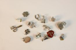 A collection of fifteen silver and white metal charms, including a thimble, scissors four leaf