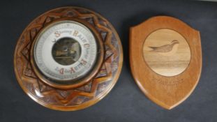An early 20th century carved oak Barometer with enamel dial along with a marquetry shield