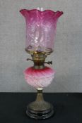 A late 19th century pink and white glass gilt metal oil lamp, raised on stepped circular base. H.