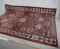 A large 20th century red ground Persian carpet with allover geometric tile pattern. L.218 W.310cm