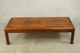 A contemporary mahogany rectangular title effect coffee table raised shaped supports. H.38 W.136 D.