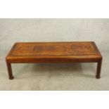 A contemporary mahogany rectangular title effect coffee table raised shaped supports. H.38 W.136 D.