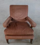 A 19th century mahogany framed open arm nursing chair, upholstered in brown fabric, raised on