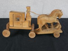 A 20th century carved hardwood toy in the form of a horse being pulling a coach, raised on wheels.