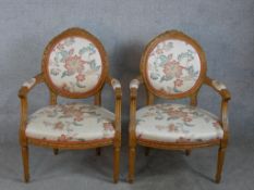 A pair of late 19th/early 20th century French style open armchairs with upholstered seats and backs,