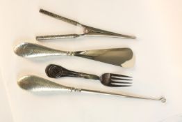 A collection of hammered silver handled tools, including boot hook, glove stretchers and shoe horn