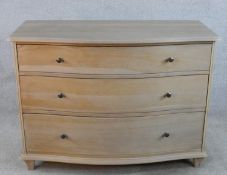 A contemporary John Lewis oak Etienne serpentine fronted chest of three graduated drawers with brass