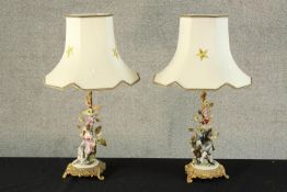A pair of 20th century Italian painted porcelain figural table lamps, each on gilt metal stands