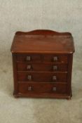 A 19th century mahogany apprentices chest of two short over three graduating drawers with turned